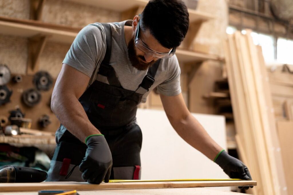Carpenter checking measurement before cutting wood