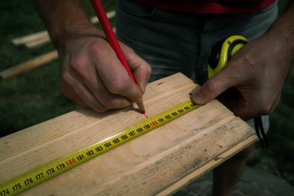 Carpenter marking cut line with sharp pencil
