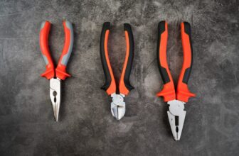 Different types of pliers including needle-nose, slip-joint, and locking pliers arranged on a workbench